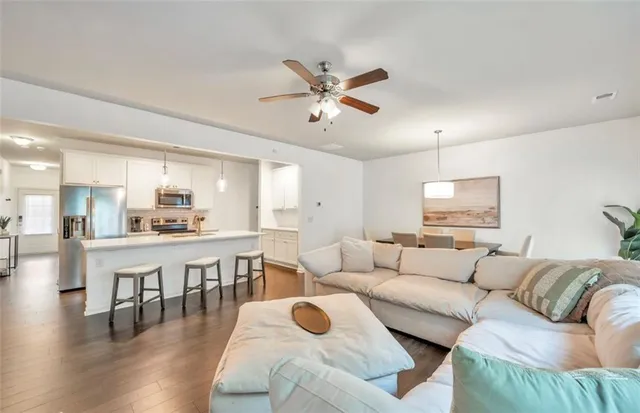 a living room with furniture and a wooden floor