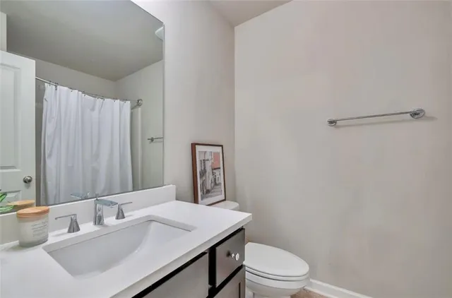 a bathroom with a sink vanity mirror and toilet