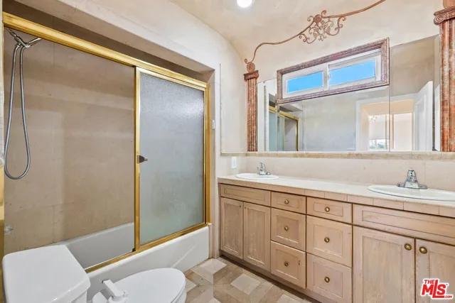 a bathroom with a granite countertop sink toilet a mirror and shower
