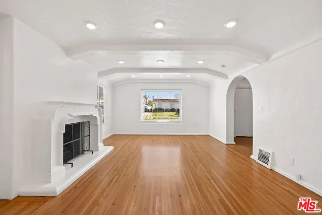 wooden floor in an empty room with a fireplace