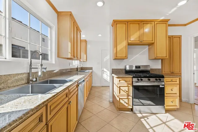 a kitchen with stainless steel appliances granite countertop a stove and a sink