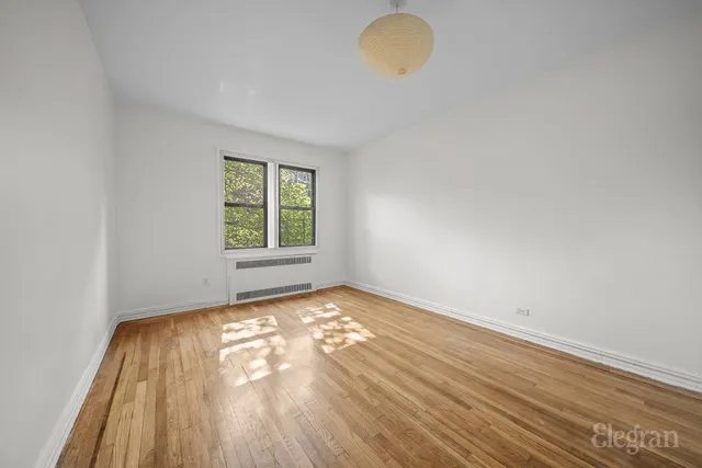 a bedroom with bed a couch and a potted plant