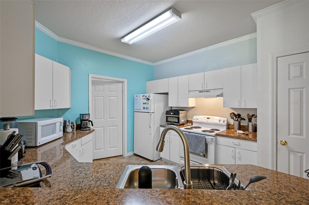 3701 Conroy Road, Unit 1812 Orlando, FL 32839 - Photo 13 of 37 a kitchen with a sink a stove and a microwave