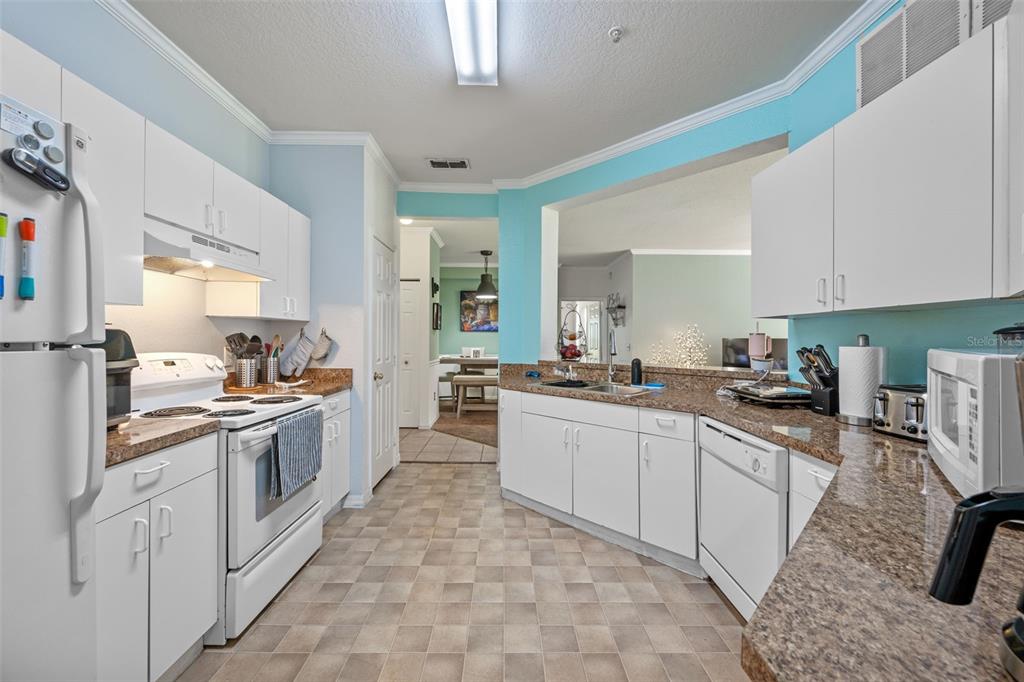 3701 Conroy Road, Unit 1812 Orlando, FL 32839 - Photo 15 of 37 a kitchen with a sink and white cabinets