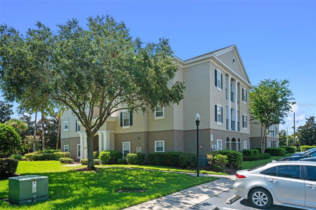 3701 Conroy Road, Unit 1812 Orlando, FL 32839 - Photo 3 of 37 a front view of a house with a garden and trees
