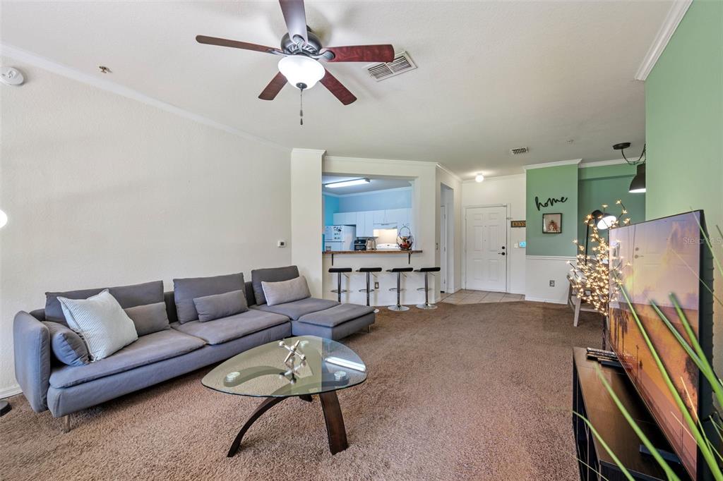 3701 Conroy Road, Unit 1812 Orlando, FL 32839 - Photo 4 of 37 a living room with furniture and a flat screen tv