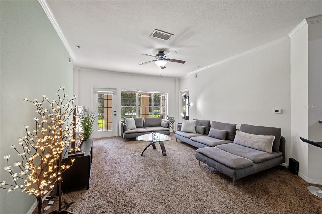 3701 Conroy Road, Unit 1812 Orlando, FL 32839 - Photo 7 of 37 a living room with furniture and a chandelier