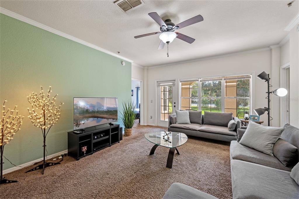 3701 Conroy Road, Unit 1812 Orlando, FL 32839 - Photo 8 of 37 a living room with furniture a lamp and a flat screen tv