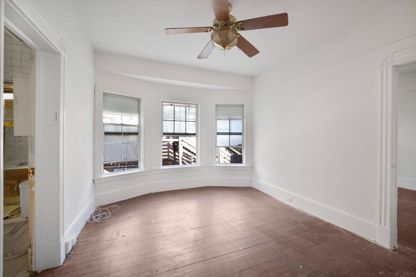 674 South 5th Street San Jose, CA 95112 - Photo 12 of 32 an empty room with wooden floor fan and windows