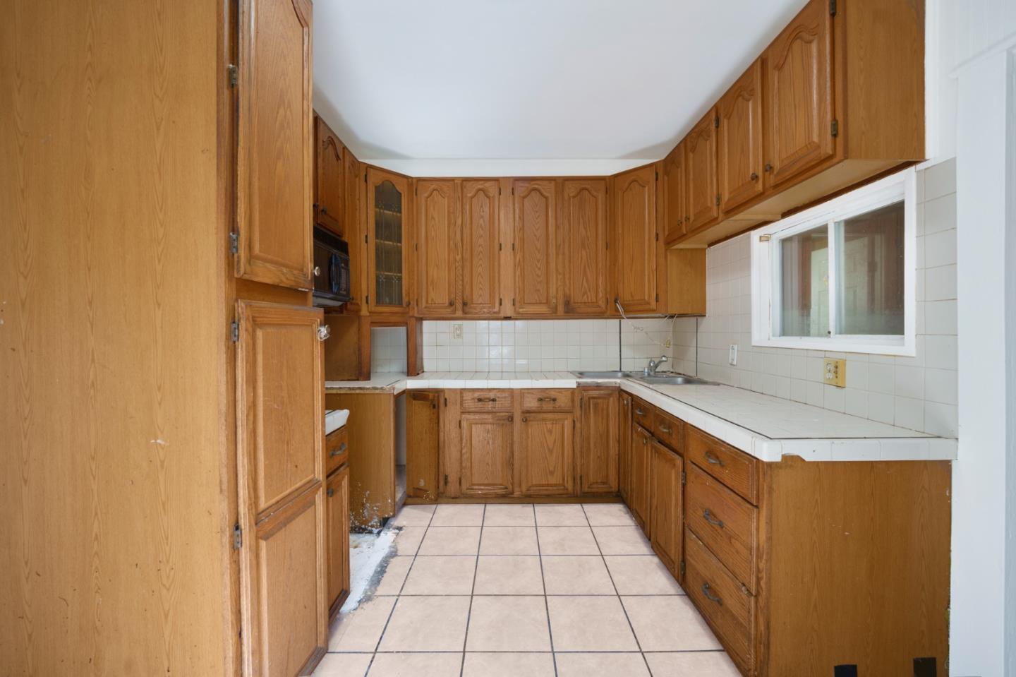 674 South 5th Street San Jose, CA 95112 - Photo 17 of 32 a kitchen with a sink a stove top oven and cabinets