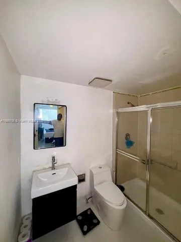 a bathroom with a toilet a sink and mirror