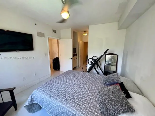 a bedroom with a bed a flat screen tv and view