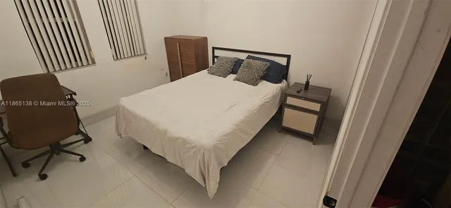 a bedroom with a bed and a chair