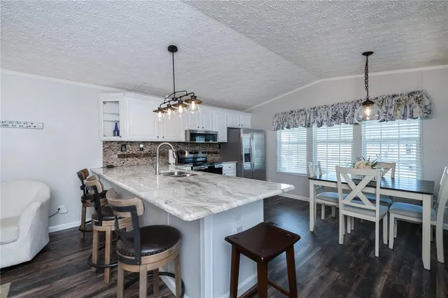 a dining room with furniture a chandelier and wooden floor