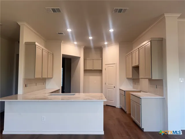 a large kitchen with stainless steel appliances granite countertop a stove a sink and a refrigerator