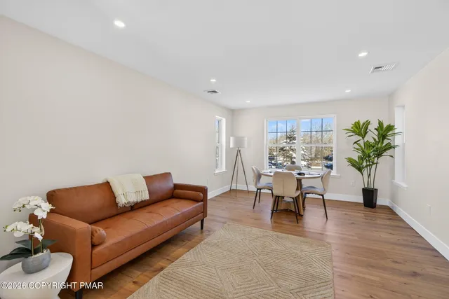 a living room with furniture and a wooden floor