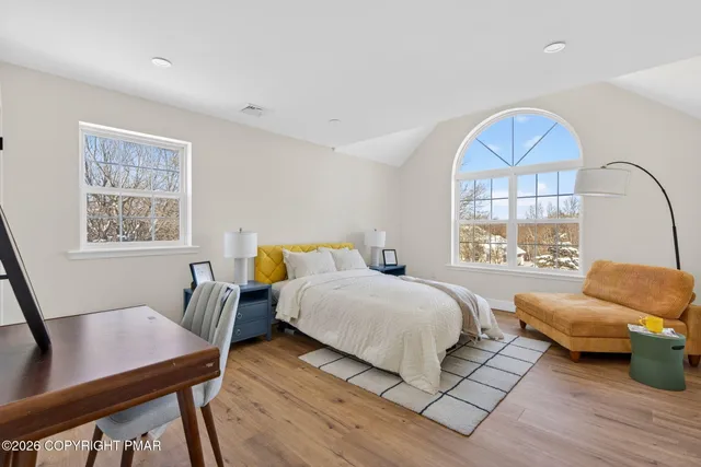 a bedroom with furniture and a large window