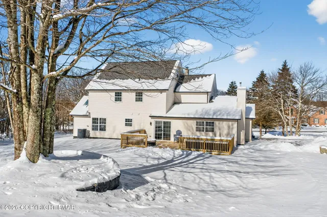 a view of a white house with a bed and wooden fence