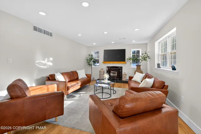 a living room with furniture a fireplace and a flat screen tv