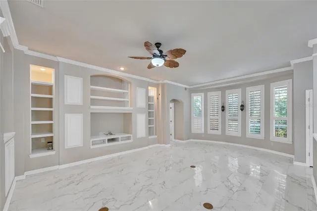 a view of an empty room with a window and a living room