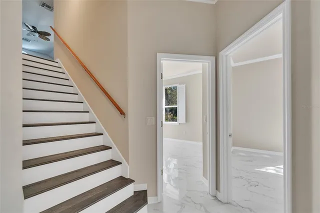 a view of an empty room with wooden floor and windows
