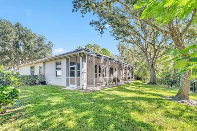 a view of a house with a big yard and large trees
