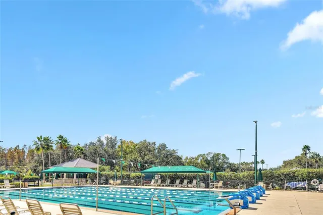a view of a house with a yard and large trees