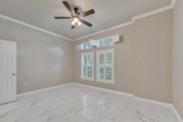 an empty room with windows and fan