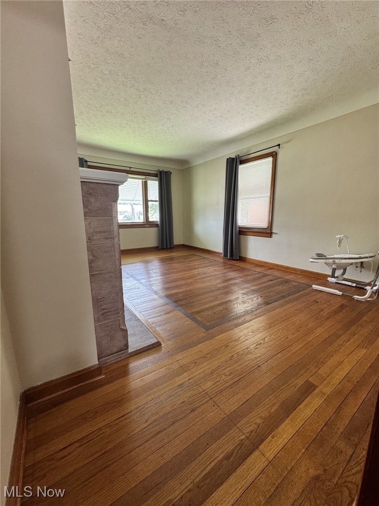 3712 Snow Road Cleveland, OH 44134 - Photo 11 of 40 Empty room with a textured ceiling and wood-type flooring