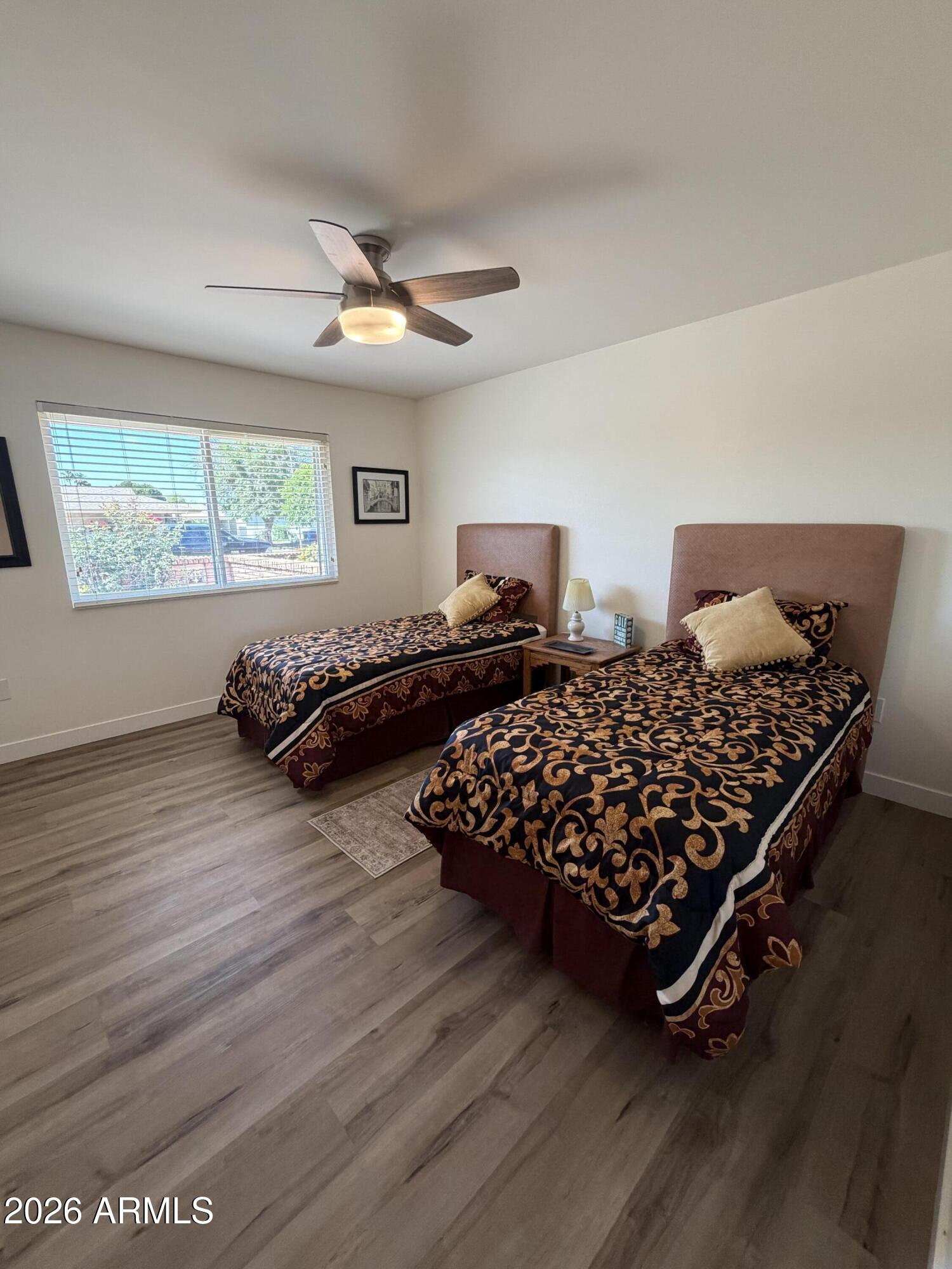 9936 West Mountain View Road Sun City, AZ 85351 - Photo 13 of 21 a bed sitting in a bedroom next to a window