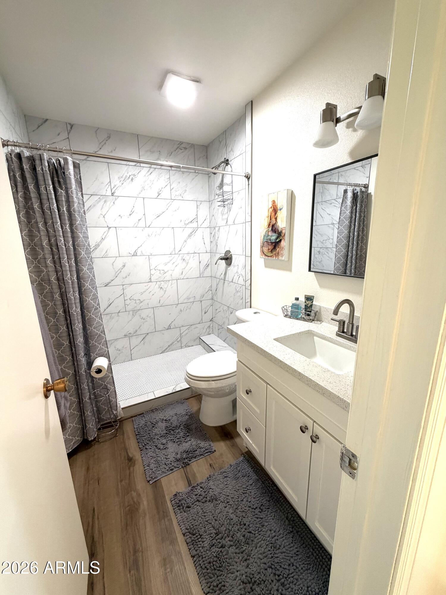9936 West Mountain View Road Sun City, AZ 85351 - Photo 14 of 21 a bathroom with a granite countertop sink toilet and shower
