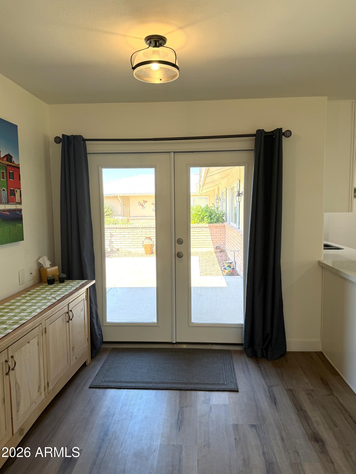 9936 West Mountain View Road Sun City, AZ 85351 - Photo 17 of 21 a view of an empty room with a window and wooden floor
