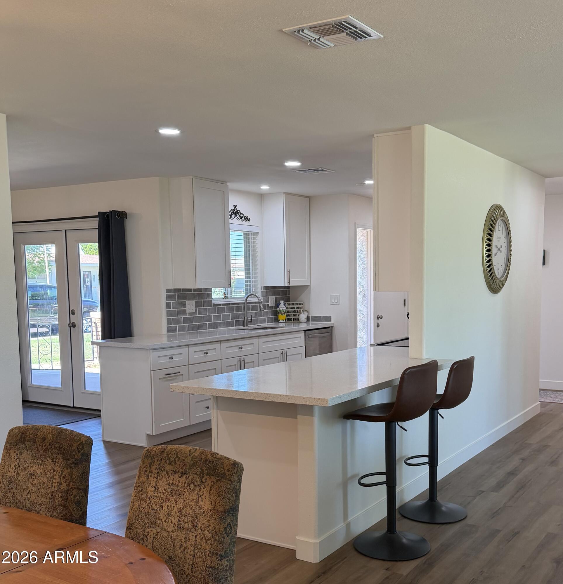 9936 West Mountain View Road Sun City, AZ 85351 - Photo 4 of 21 a kitchen with kitchen island granite countertop a table and a chair