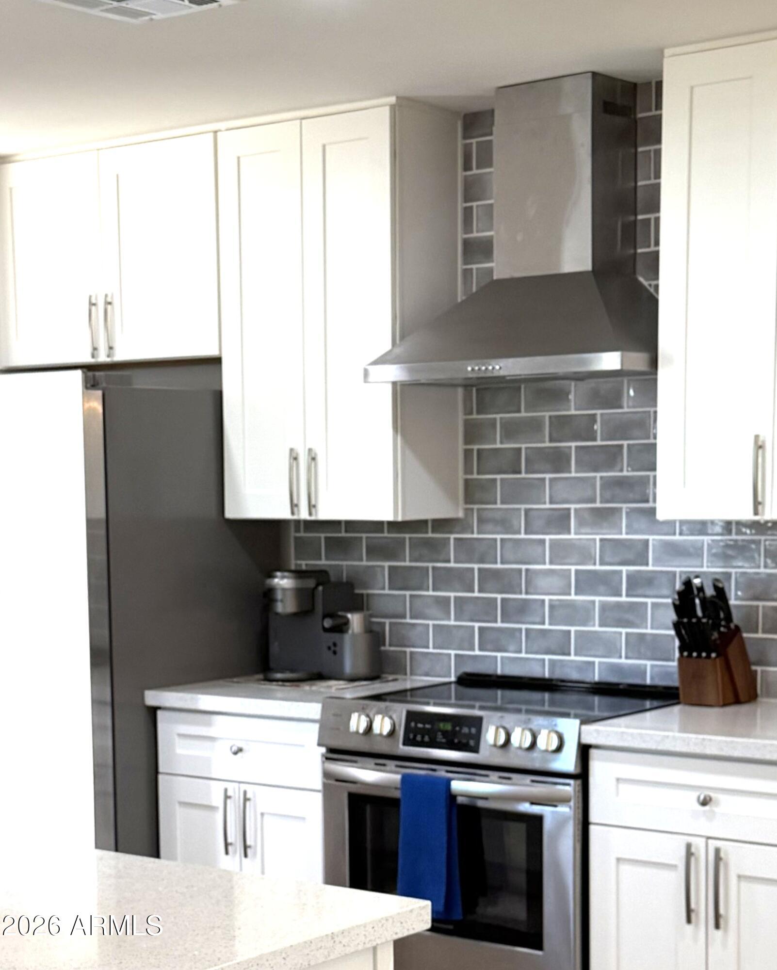 9936 West Mountain View Road Sun City, AZ 85351 - Photo 5 of 21 a kitchen with a stove and a white cabinet