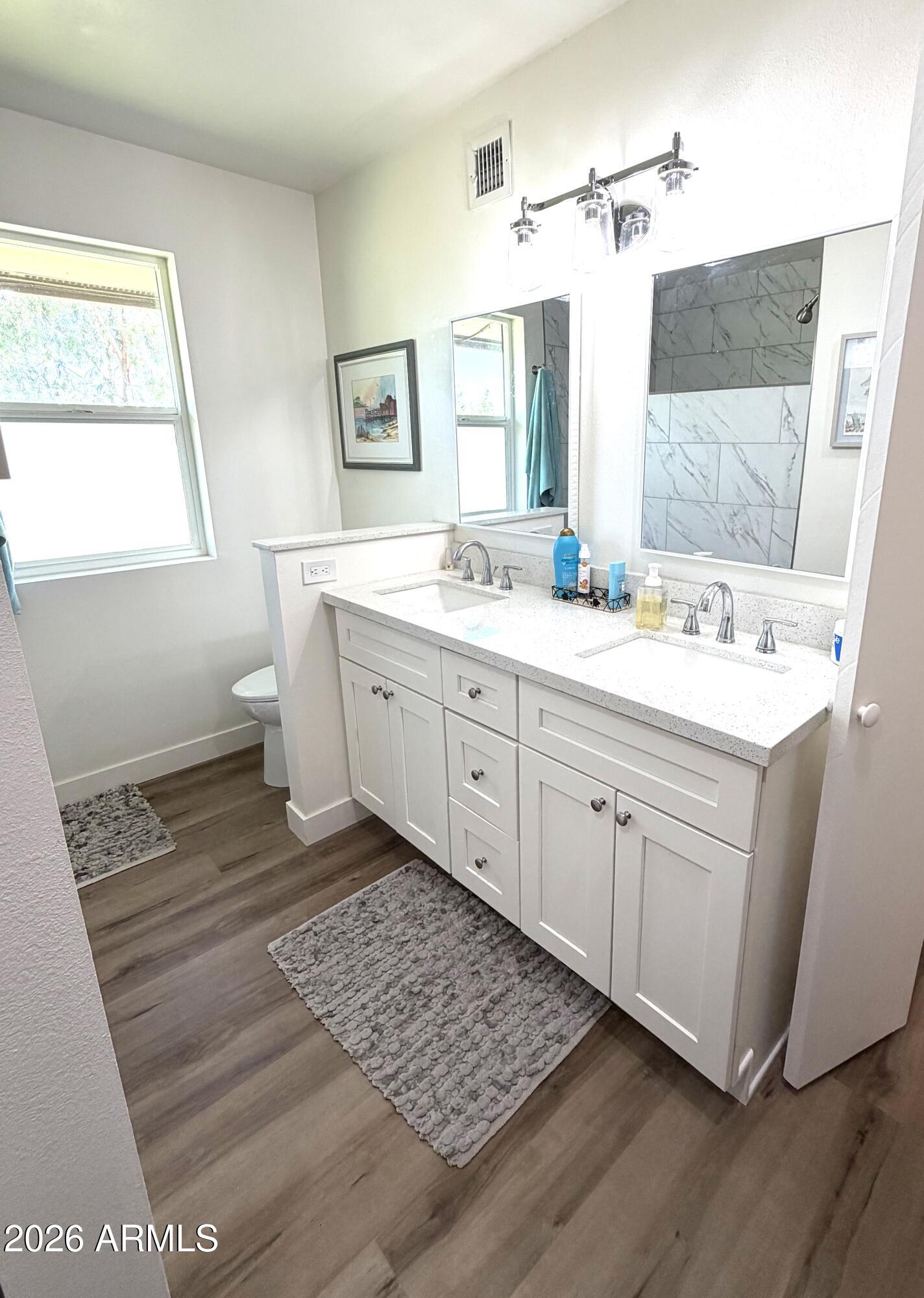 9936 West Mountain View Road Sun City, AZ 85351 - Photo 10 of 21 a spacious bathroom with a double vanity sink a mirror and a