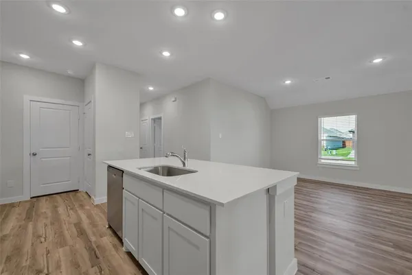 a kitchen with a sink and wooden floor