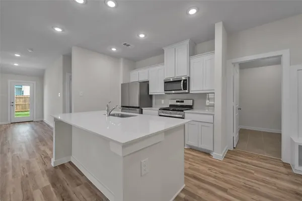 a kitchen with appliances a sink and cabinets
