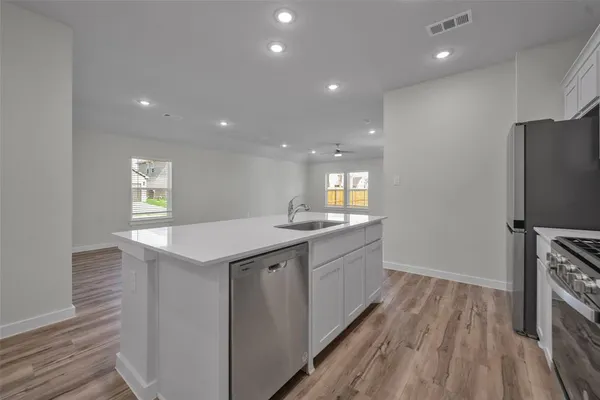 a kitchen with granite countertop a refrigerator and a sink