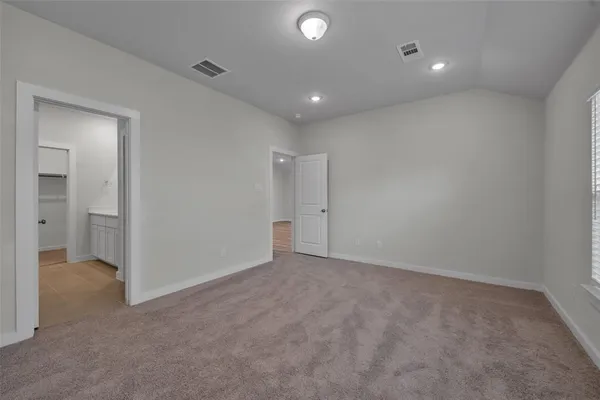 an empty room with closet and a bathroom