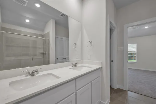 a bathroom with double vanity sinks and a mirror