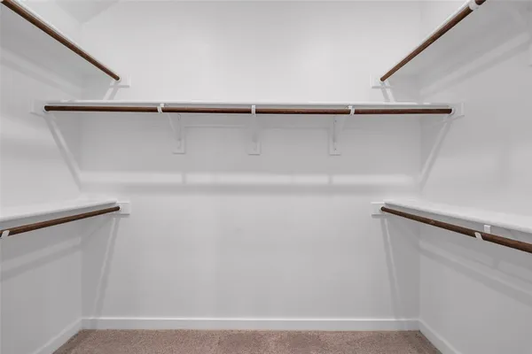 a view of walk in closet with empty racks