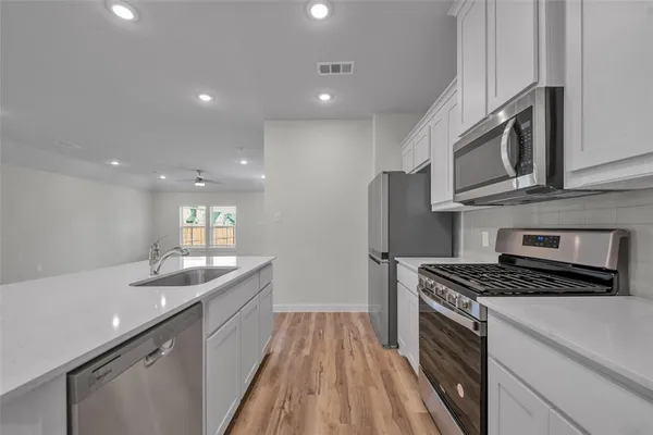 a kitchen with stainless steel appliances granite countertop a sink stove and cabinets