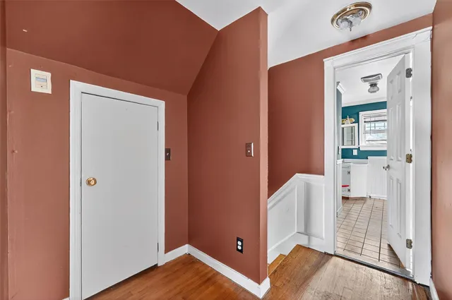 an empty room with wooden floor windows and ceiling fan
