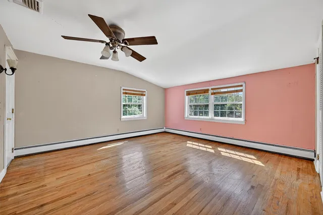 a view of an empty room with wooden floor