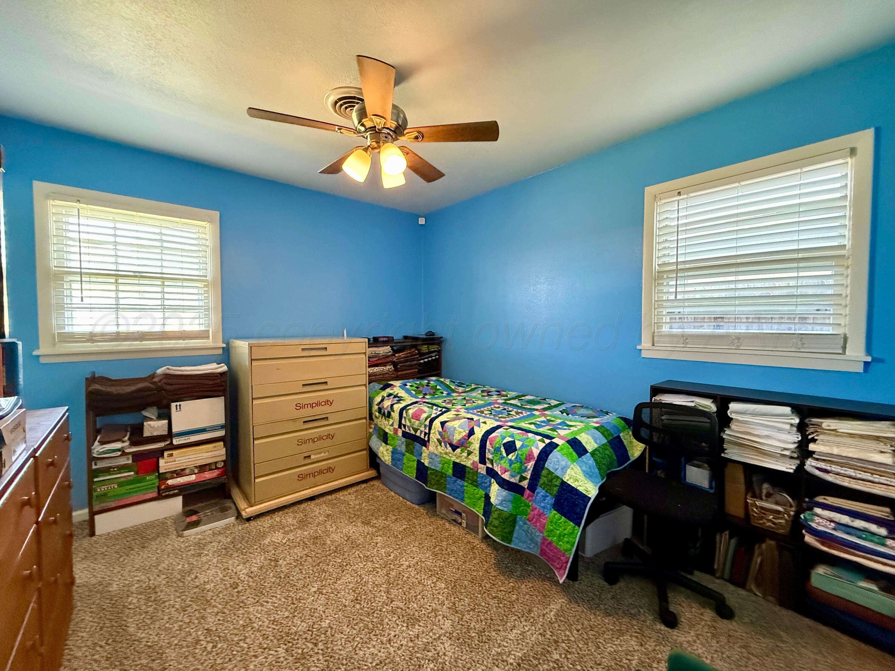 4600 South Bryan Street Amarillo, TX 79110 - Photo 8 of 13 a bedroom with a bed and a chandelier