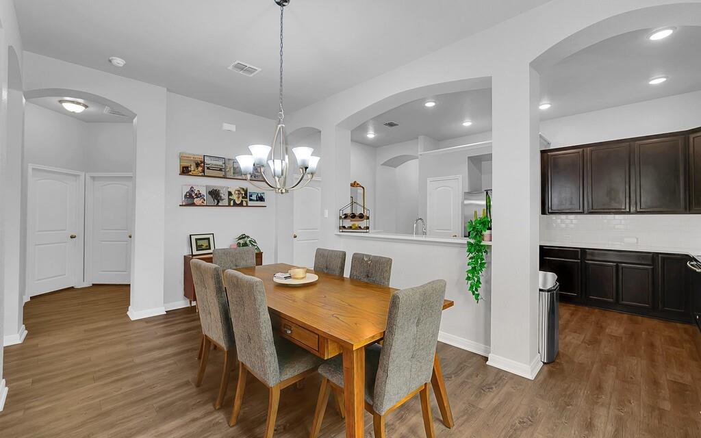 2720 Beutel Road Lorena, TX 76655 - Photo 15 of 37 Dining space featuring arched walkways, light wood-style flooring, and a chandelier