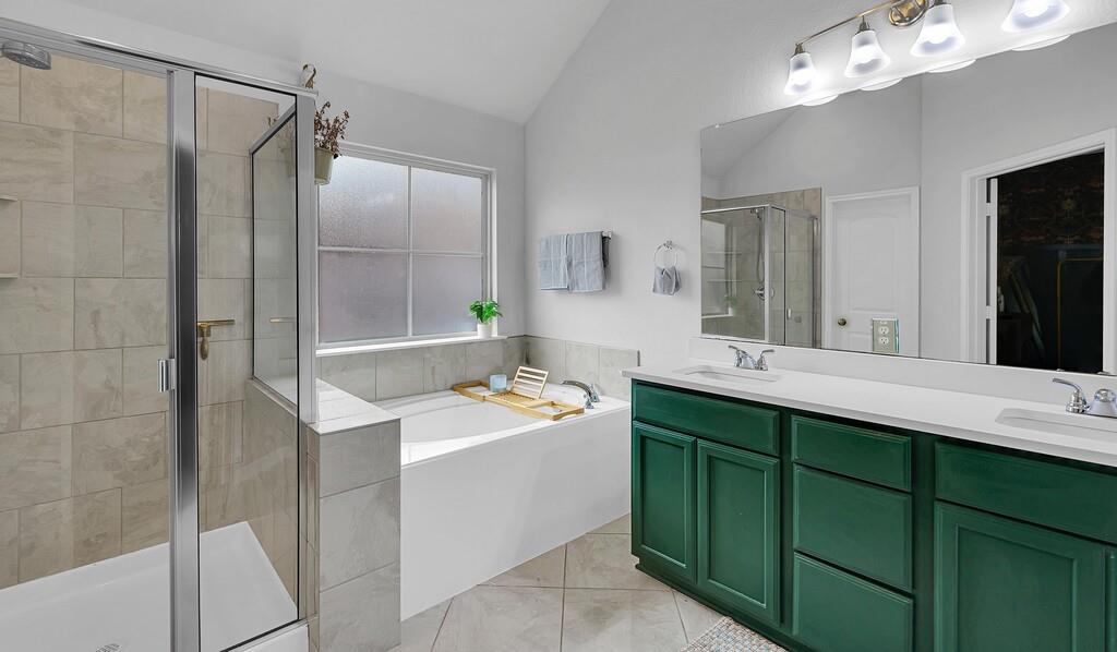 2720 Beutel Road Lorena, TX 76655 - Photo 18 of 37 Full bath featuring a garden tub, light tile patterned flooring, double vanity, lofted ceiling, and a stall shower