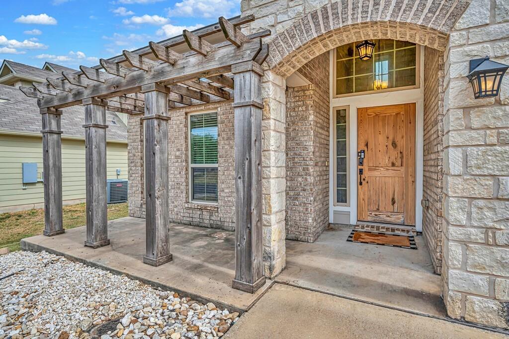 2720 Beutel Road Lorena, TX 76655 - Photo 3 of 37 Property entrance with brick siding, a pergola, and stone siding