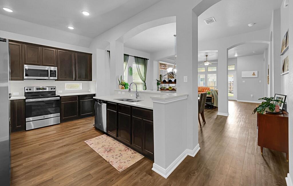 2720 Beutel Road Lorena, TX 76655 - Photo 5 of 37 Kitchen with stainless steel appliances, dark brown cabinets, dark wood-style flooring, a ceiling fan, and recessed lighting