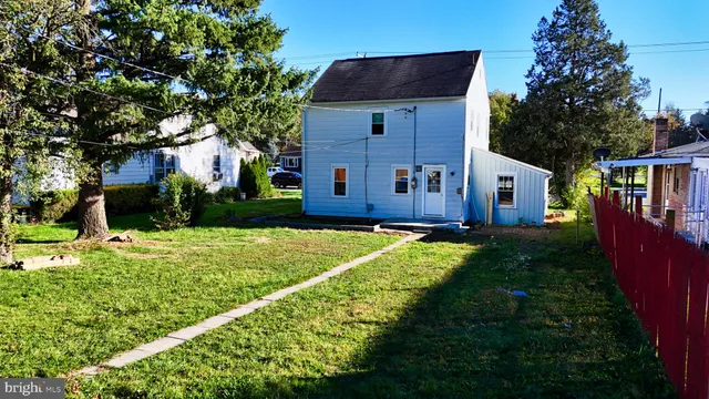 a view of house with backyard and tub